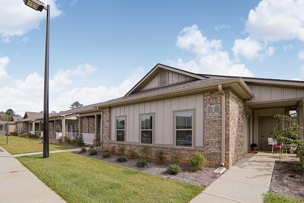 a row of houses with a lawn and a sidewalk
