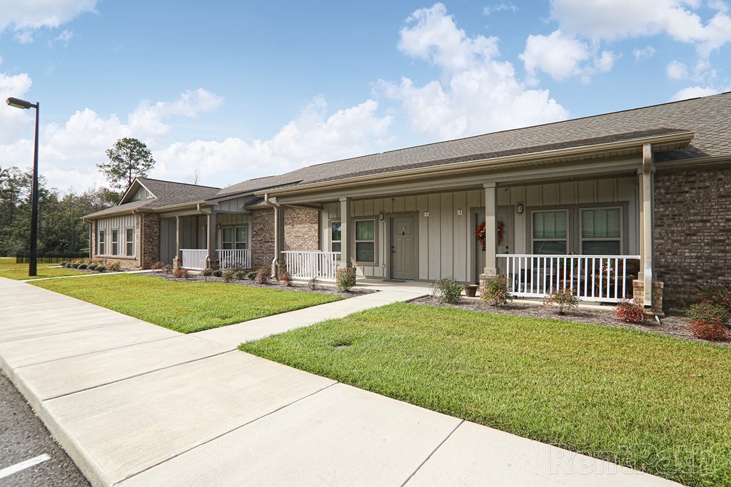 a white and brick house with a porch and a lawn