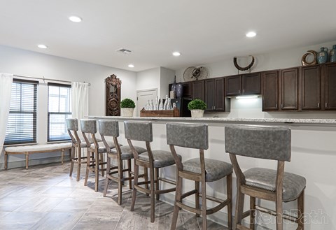 a kitchen with a bar with chairs in front of it