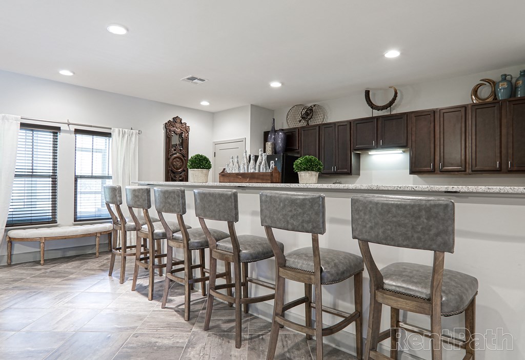 a kitchen with a bar with chairs in front of it