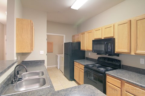 a kitchen with black appliances and granite counter tops