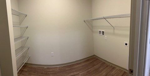 Empty walk-in closet with shelves and a wooden floor.at Arbours at Moores Mill, Huntsville Alabama