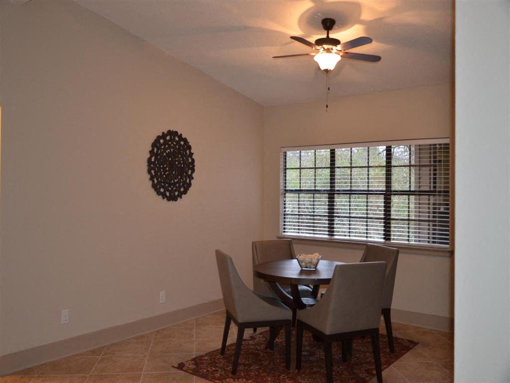 a dining room with a ceiling fan and a table and chairs