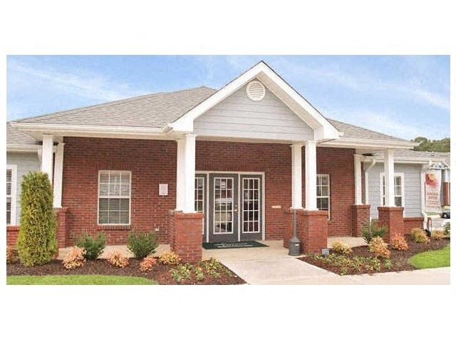 a brick house with a front porch and a driveway
