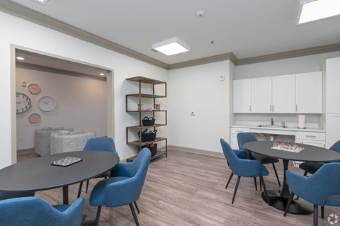 A dining room with a round table and blue chairs.