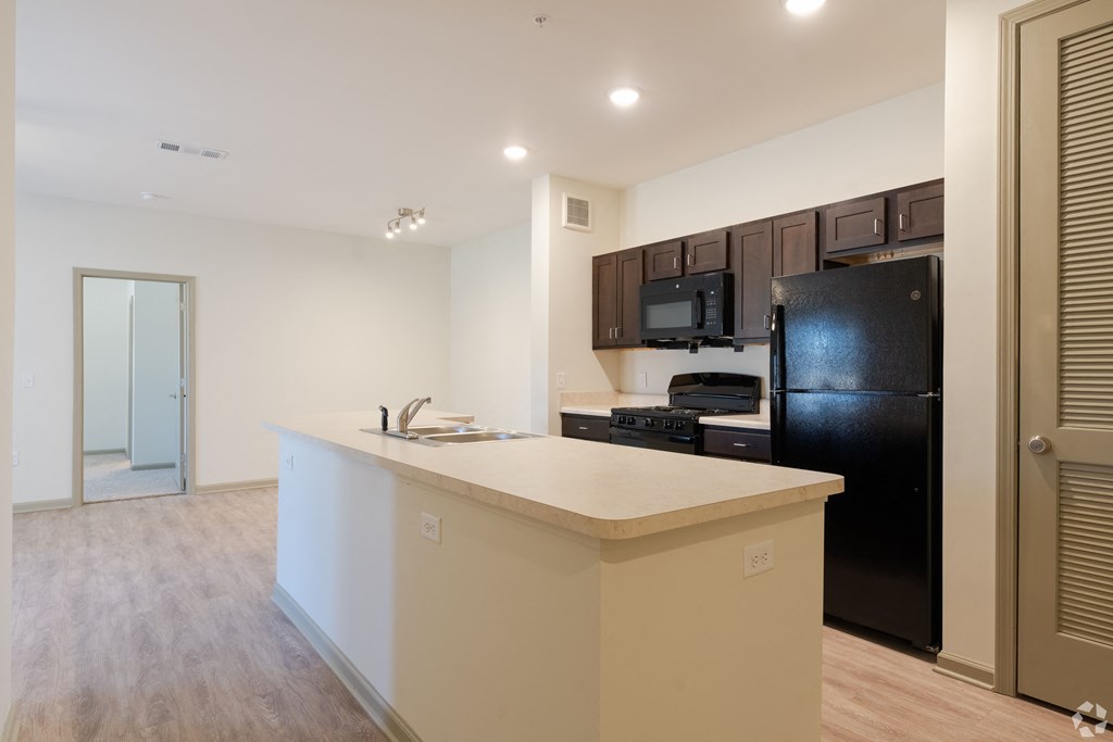 a kitchen with a large island and a black refrigerator