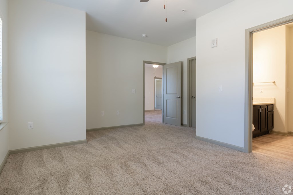 a living room with a carpeted floor and a hallway with a door to a
