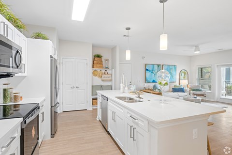 A modern kitchen with white cabinets and appliances.