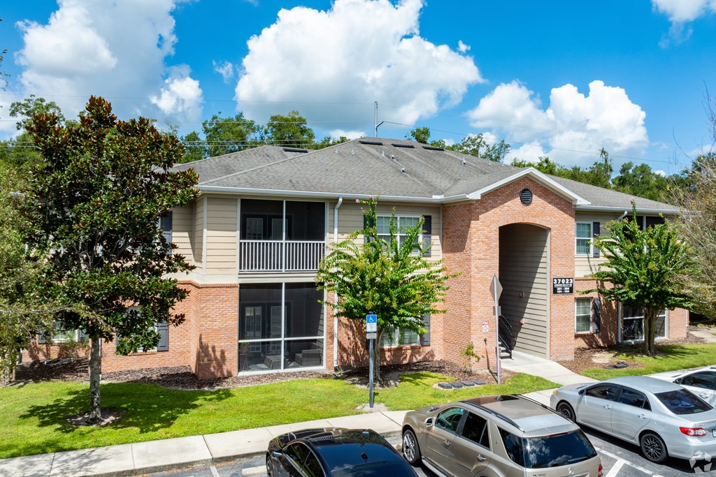 A residential building with a parking lot in front.