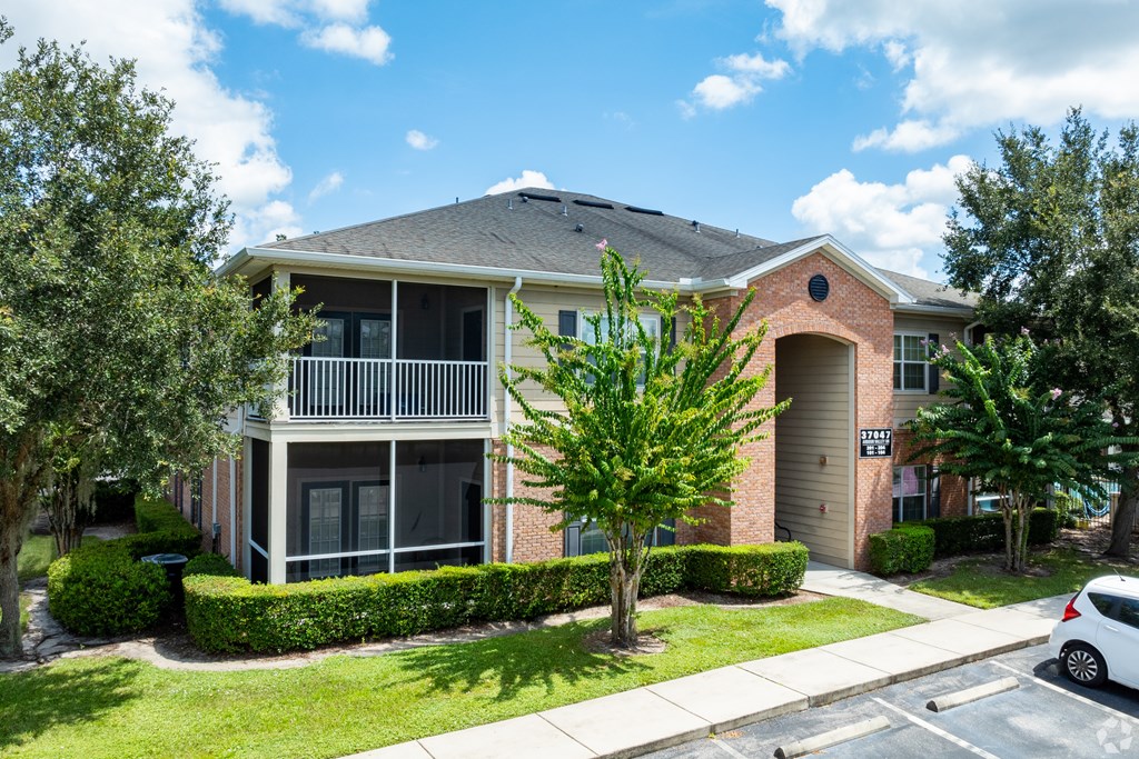 A two-story brick house with a balcony on the second floor.