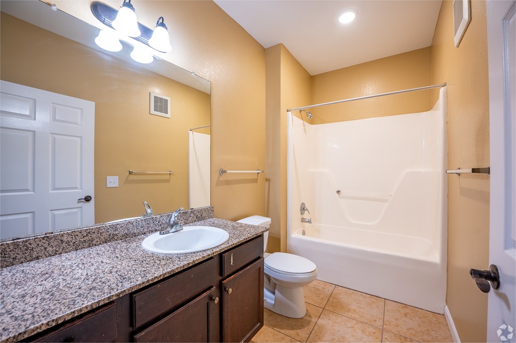 A bathroom with a sink, toilet, and bathtub.