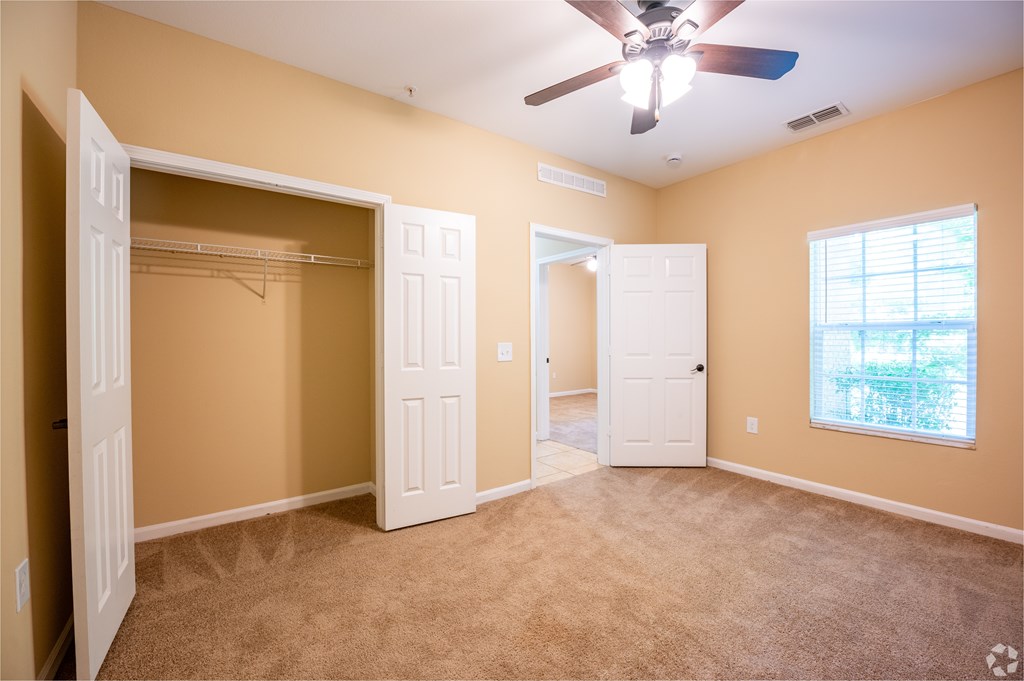 A room with a ceiling fan and a window.