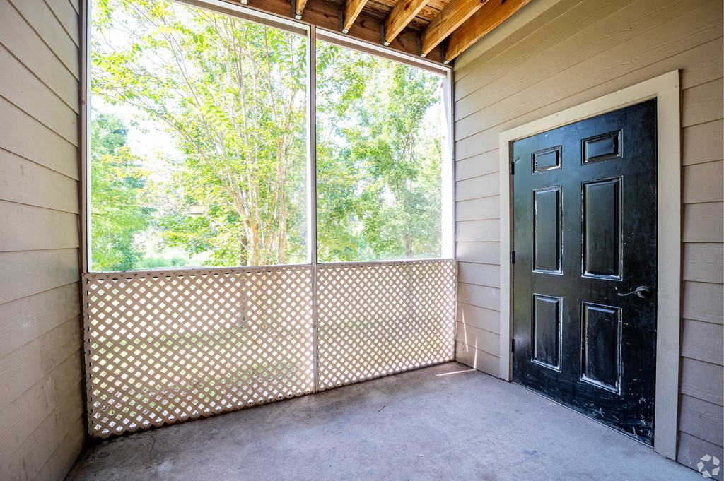 A black door is on the right side of a screened window.