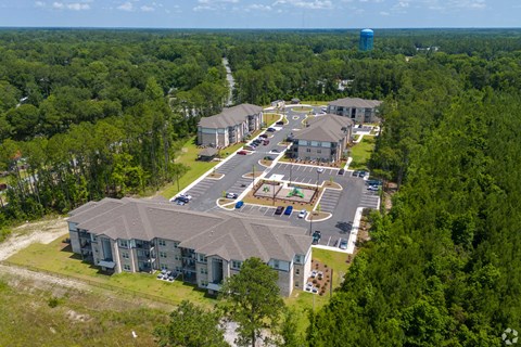 An aerial view of a large building surrounded by trees. at Arbours at Kingsland, Kingsland, 31548