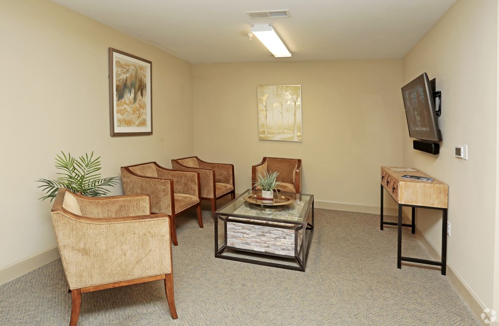 A living room with a couch, chairs, a coffee table, and a television at Arbours at Tumblin Creek ~ Active 55+ Adult Community, Gainesville, Florida