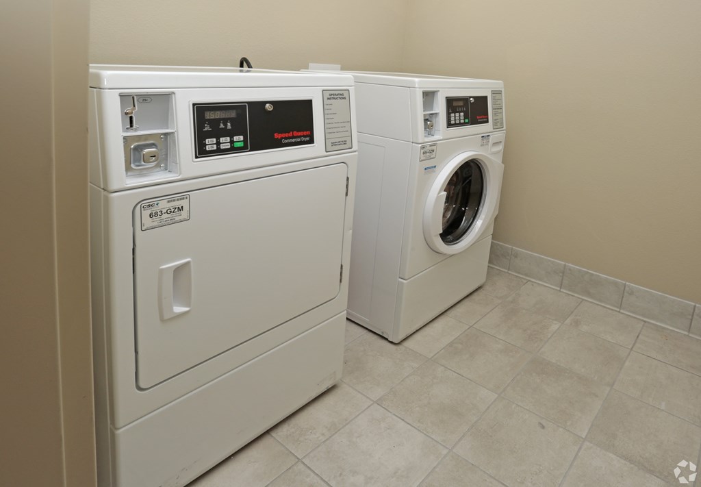 Two front loading washing machines in a laundry room at Arbours at Tumblin Creek ~ Active 55+ Adult Community, Gainesville, FL 32608