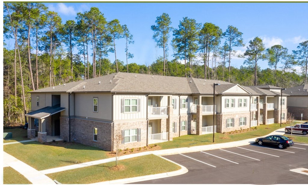 A large building with a parking lot in front of it at Arbours at Satsuma Apartments, Mobile