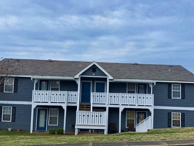 a blue house with a white porch and a blue sky