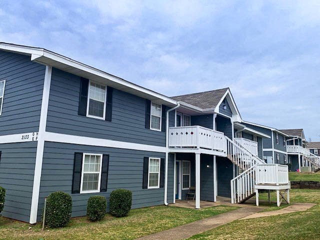 a blue house with a white porch and stairs