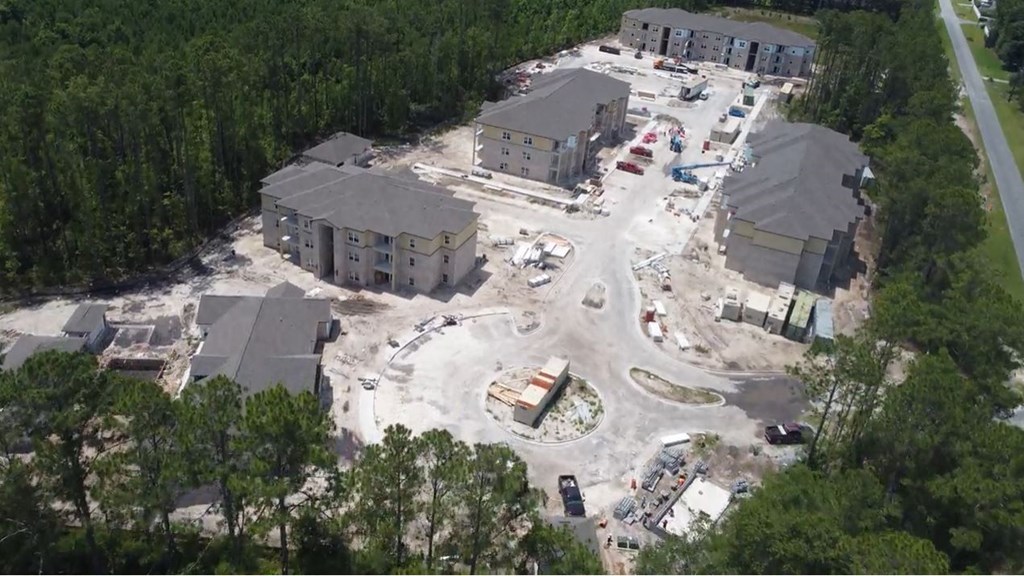 an aerial view of a construction site with buildings and trees