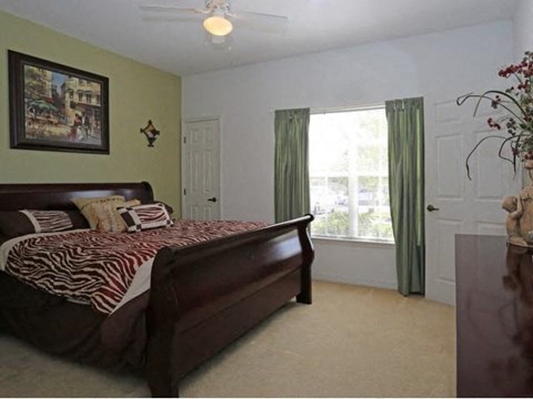 A bedroom with a bed and a painting on the wall.