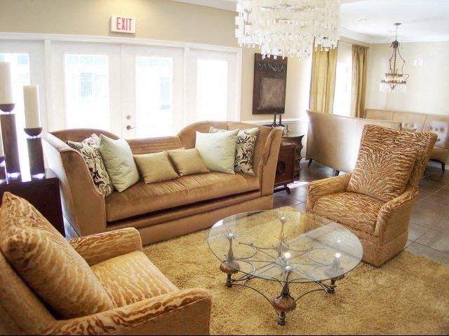 a living room with couches and chairs and a glass table