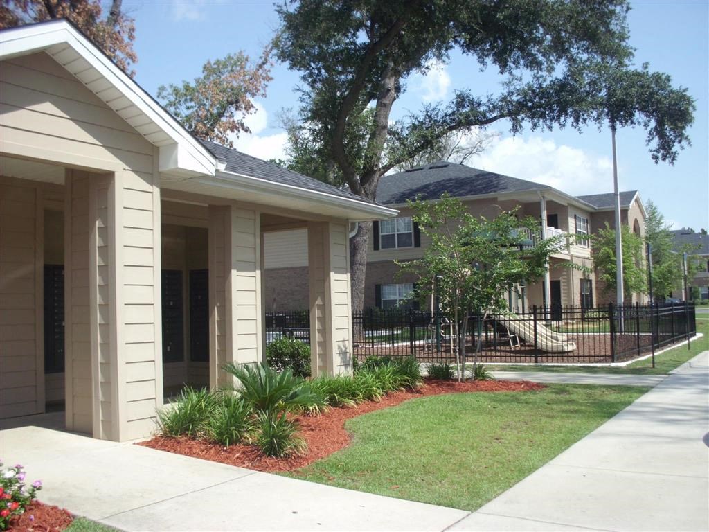 a house with a yard and a fence in front of it