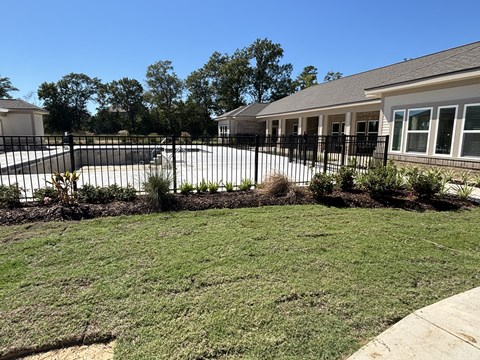 A house with a black fence and a green lawn at Arbours at Lake Charles, Lake Charles, Louisiana