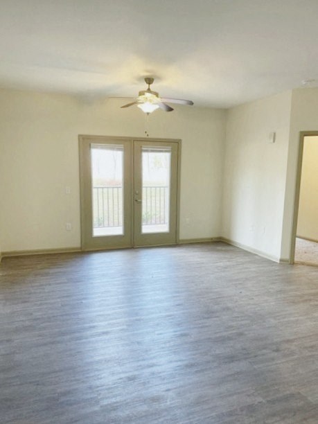an empty living room with a ceiling fan