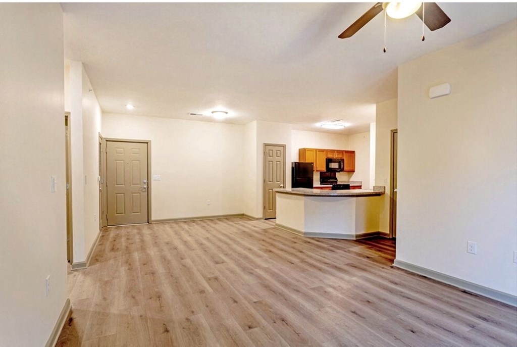 A room with a wooden floor and a ceiling fan at Arbours at Satsuma Apartments, Mobile, Alabama