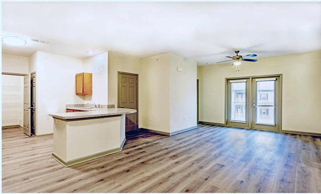 A room with a wooden floor and a white ceiling with a fan at Arbours at Satsuma Apartments, Mobile