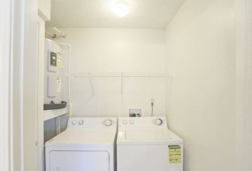 a white laundry room with two washes and a dryer