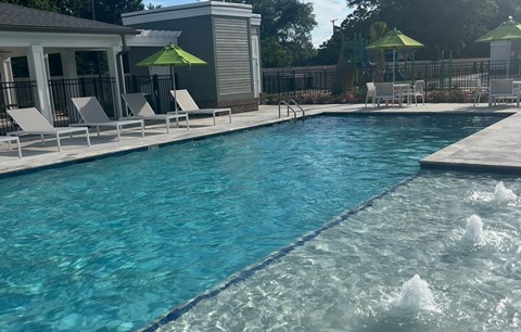 A pool with a fountain in the middle of it.