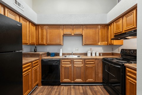 A kitchen with wooden cabinets and black appliances.