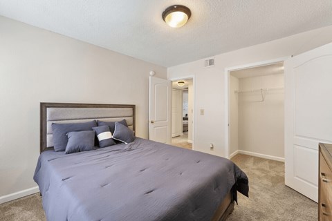 A bedroom with a bed, dresser, and mirror.