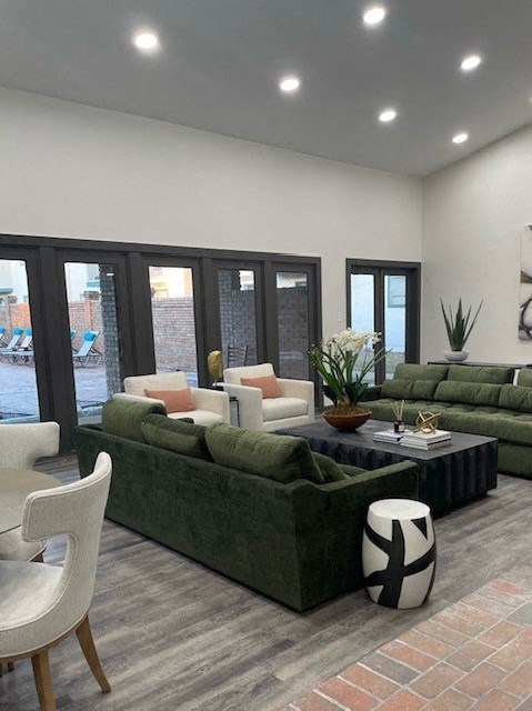 A living room with a green couch and a white chair.