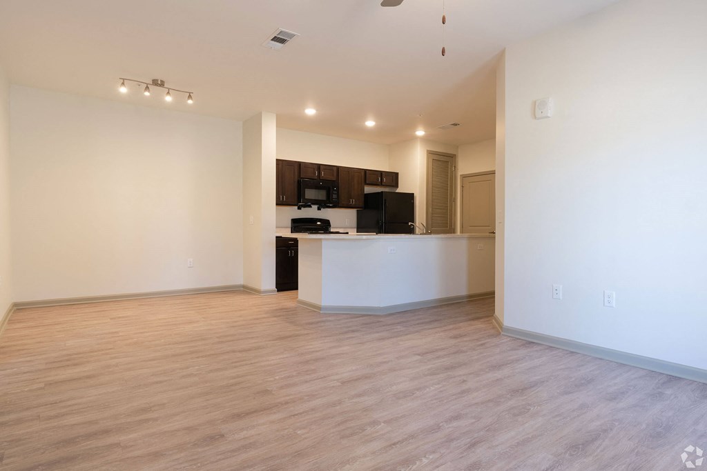 A spacious living room with a kitchenette in the background. at Arbours at Villa Rica, LLC, Villa Rica, GA, 30180