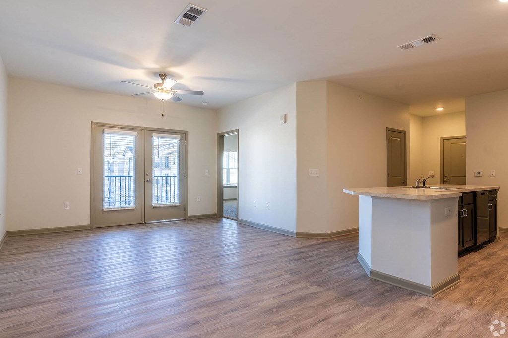 A spacious room with a kitchen area and a ceiling fan. at Arbours at Villa Rica, LLC, Villa Rica, Georgia