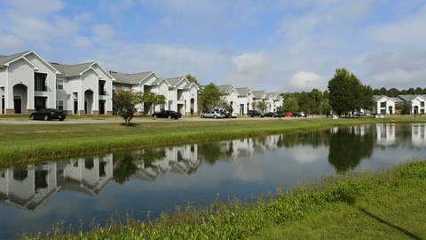 A row of houses are reflected in the water.