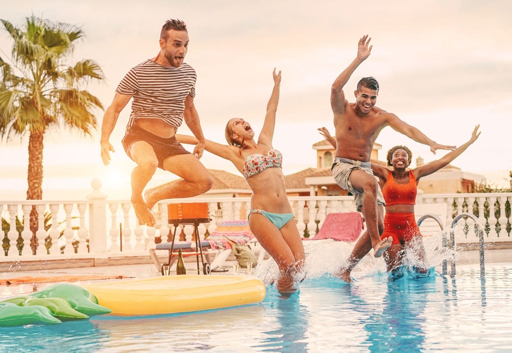 a group of young people jumping into a swimming pool
