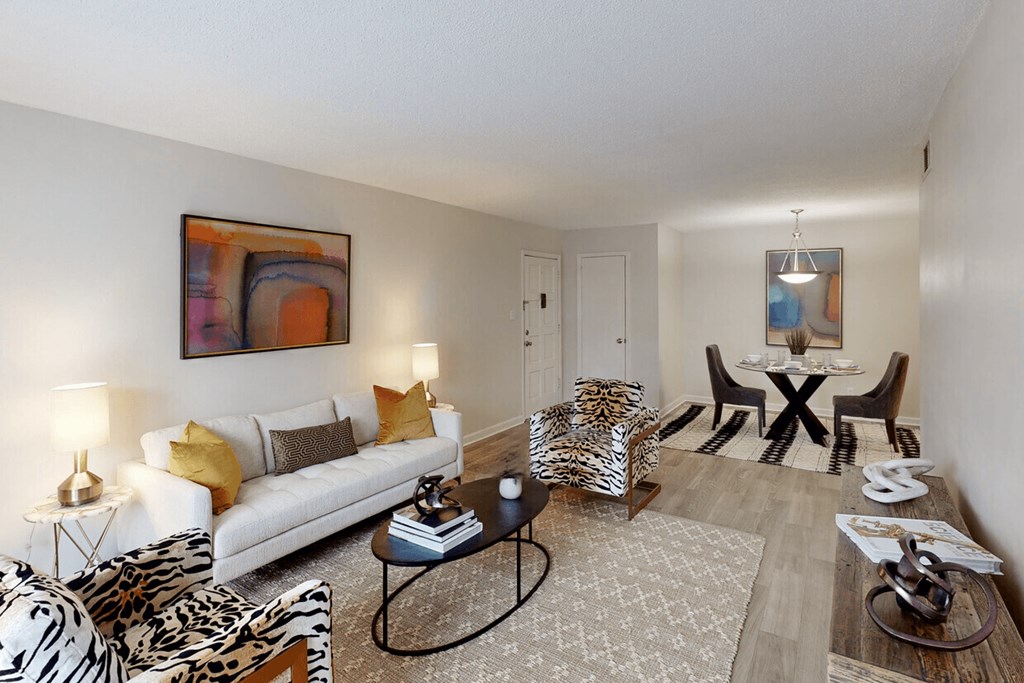 A living room with a zebra print chair and a white couch.