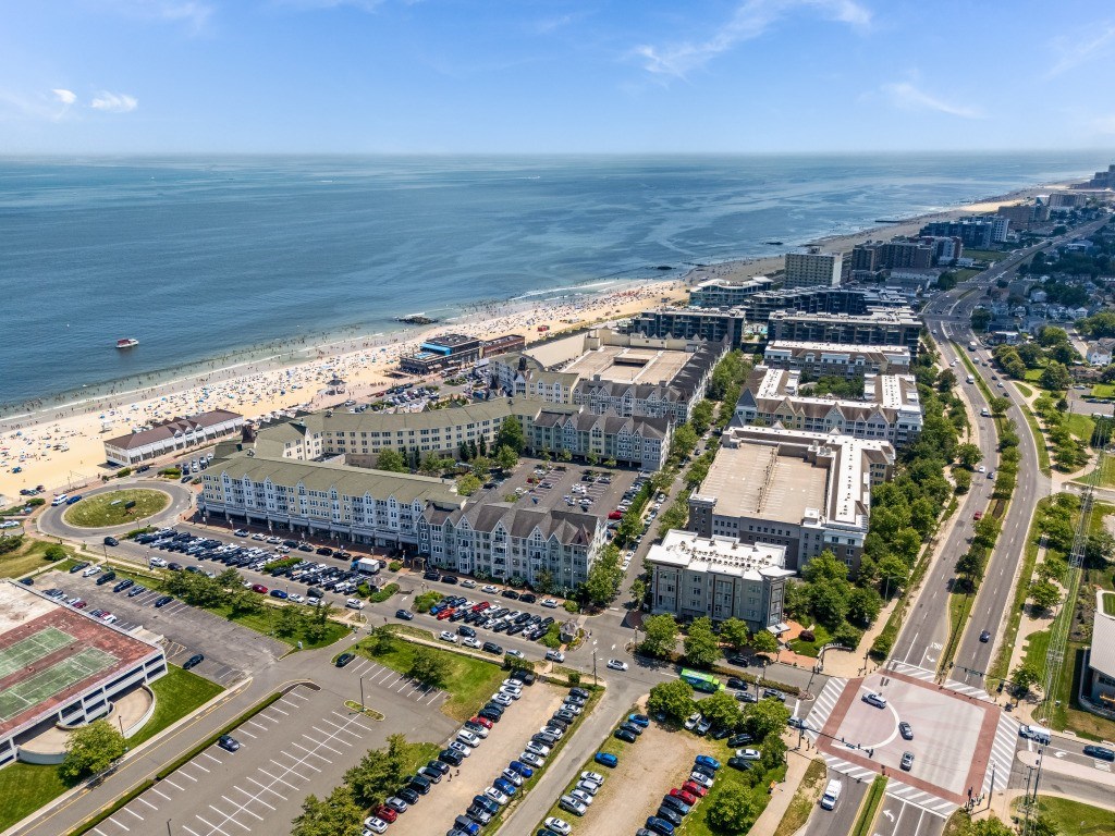 A beachfront cityscape with a parking lot in the foreground.