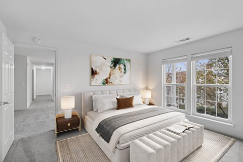 A bedroom with a large bed and a painting on the wall.