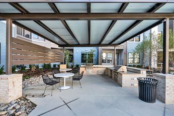 A patio with a table and chairs under a roof.