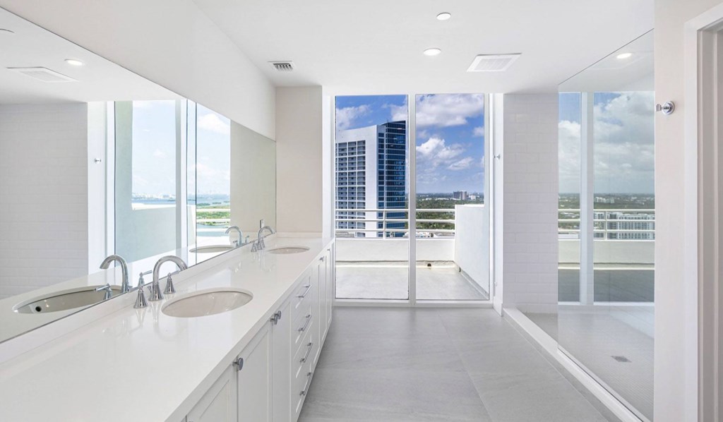 A modern bathroom with a view of the city.