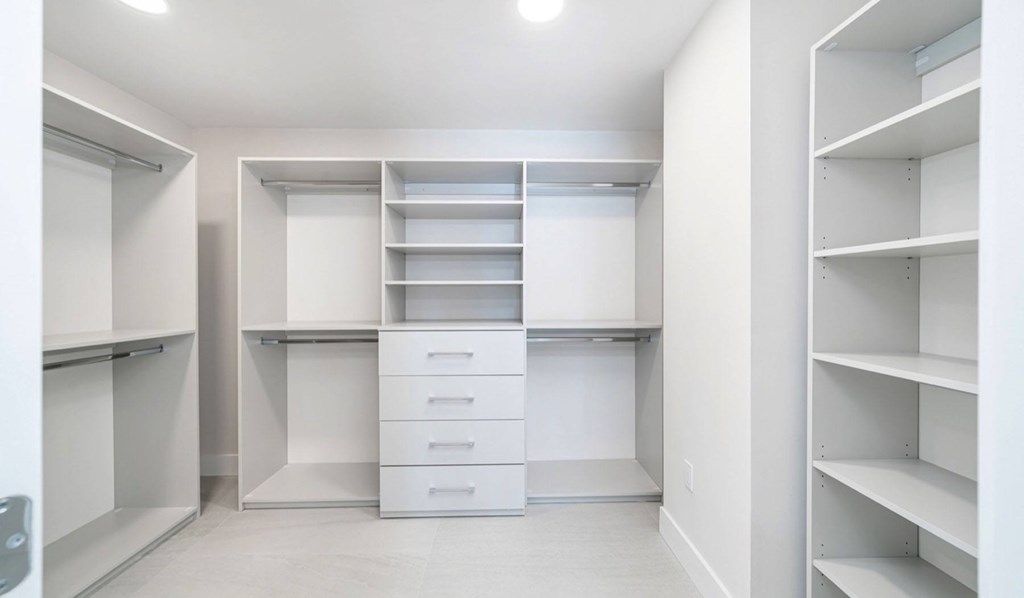 A white pantry with shelves and drawers.