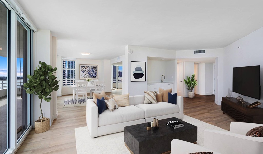 A modern living room with a white sofa set and a black coffee table.