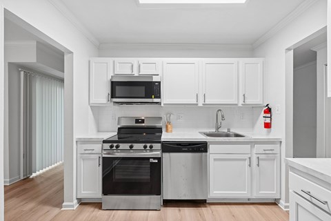 A modern kitchen with white cabinets and stainless steel appliances.