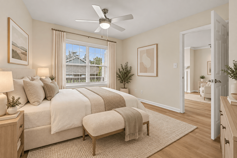 A bedroom with a large bed and a ceiling fan.