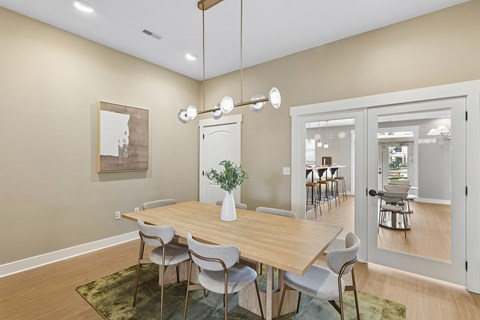 A dining room with a wooden table and chairs.
